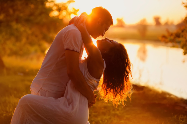 Young beautiful couple in white dancing on the background of sunset - Fotó, kép