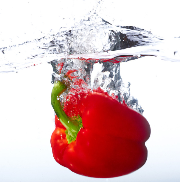 Fresh red paprika falling into the water with a splash of water - Zdjęcie, obraz