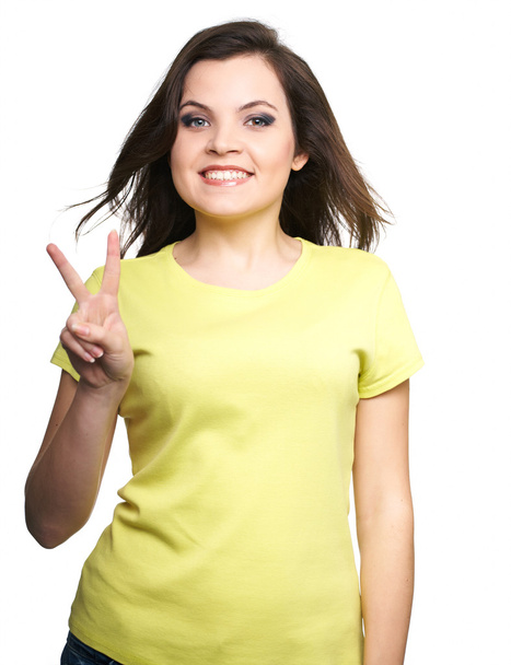 Привлекательная молодая женщина в жёлтой рубашке. Женщина показывает символ о
 - Фото, изображение