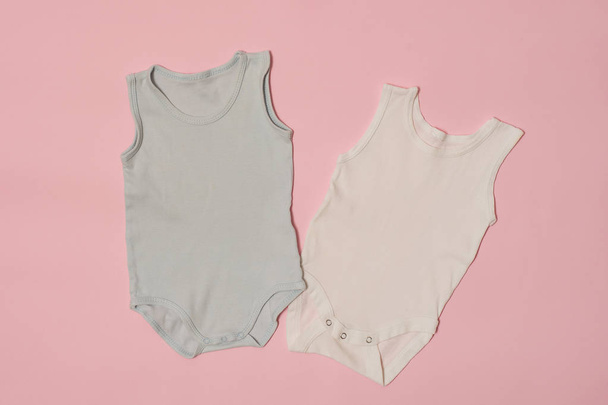 ピンクの背景の青と白の赤ちゃんボディー スーツ。ファッションの概念 - 写真・画像