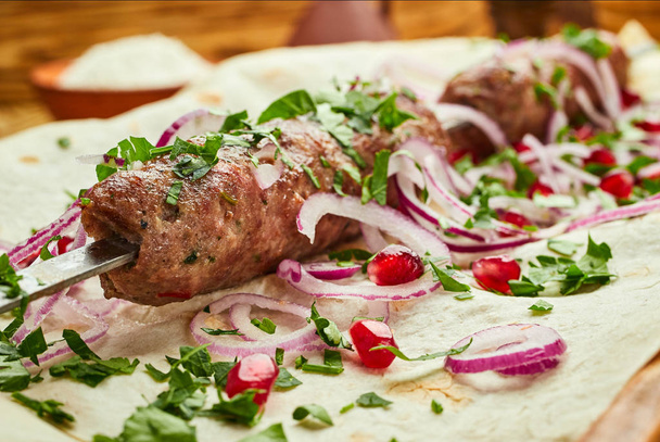Lula kebab, piatto georgiano con carne servita da cipolle e verdure nel pane pita
 - Foto, immagini