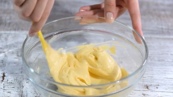 Chiudete. Mani di pasticceria mescolare crema di formaggio nella ciotola
. - Filmati, video