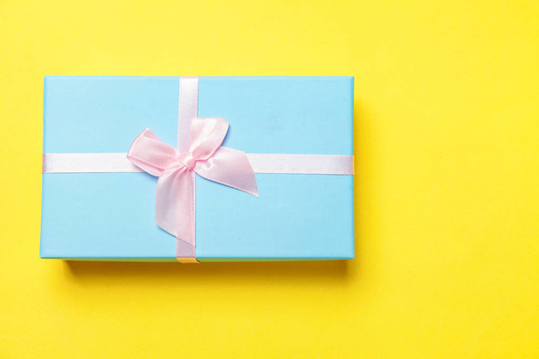 Yılbaşı yeni yıl doğum günü Sevgililer günü kutlama romantik kavramı mevcut. Sarı arka plan üzerinde izole mavi hediye kutusu - Fotoğraf, Görsel