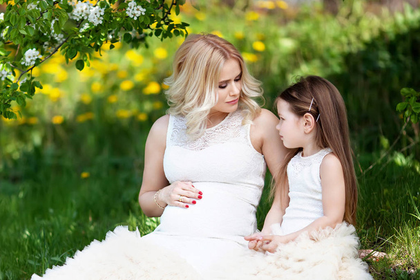 Pregnant mother and her small daughter have fun outdoor. Family  - Photo, Image