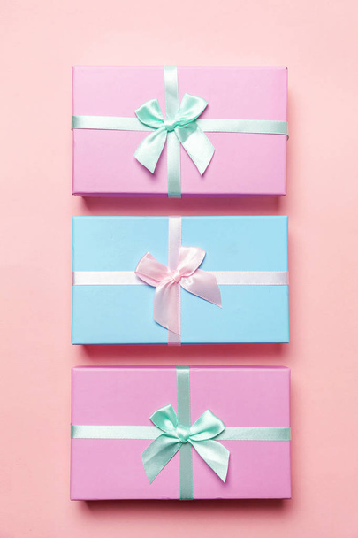 Kerstmis-Nieuwjaar Valentijn verjaardag romantische concept voorleggen. Drie roze en blauwe cadeau boxex geïsoleerd op roze achtergrond - Foto, afbeelding