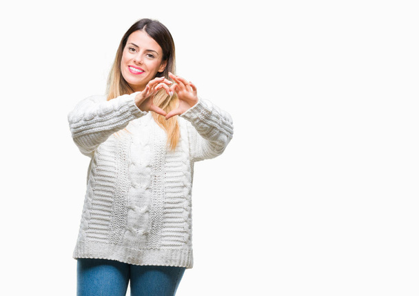 Young beautiful woman casual white sweater over isolated background smiling in love showing heart symbol and shape with hands. Romantic concept. - Photo, Image