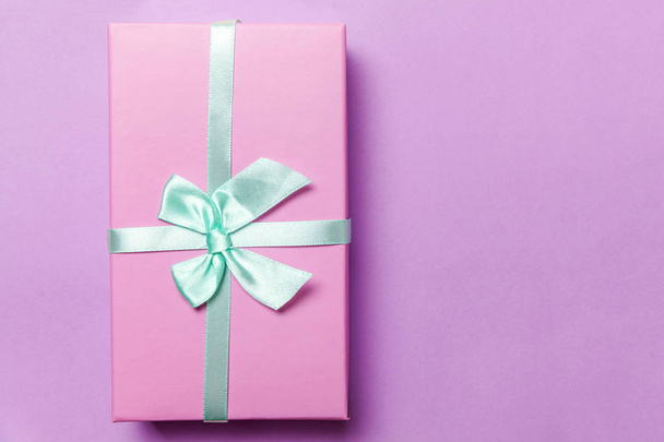 Karácsonyi-újévi születésnap Valentin jelen romantikus fogalmát. Rózsaszín ajándék doboz elszigetelt lila háttér - Fotó, kép