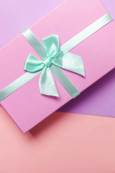 Christmas New Year birthday valentine celebration present romantic concept. Pink gift box isolated on purple background - Photo, image