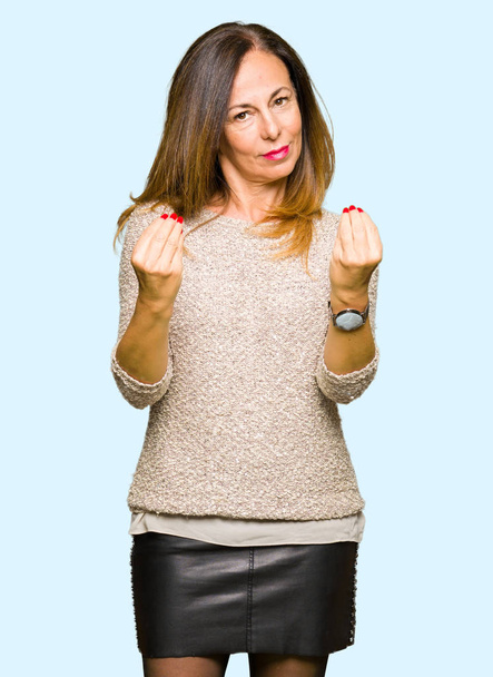 Красивая женщина средних лет в модном свитере делает денежный жест рукой, просит зарплату, миллионерский бизнес
 - Фото, изображение