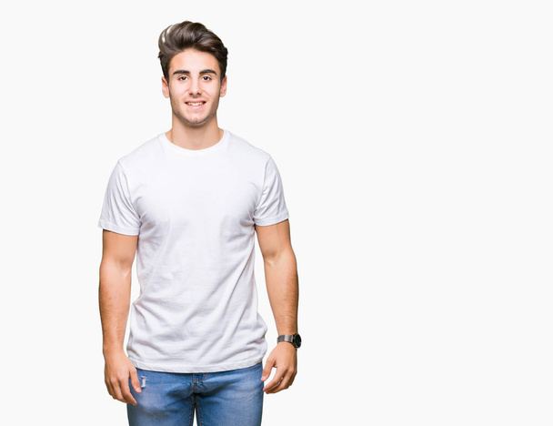 Young handsome man wearing white t-shirt over isolated background with a happy and cool smile on face. Lucky person. - Photo, image