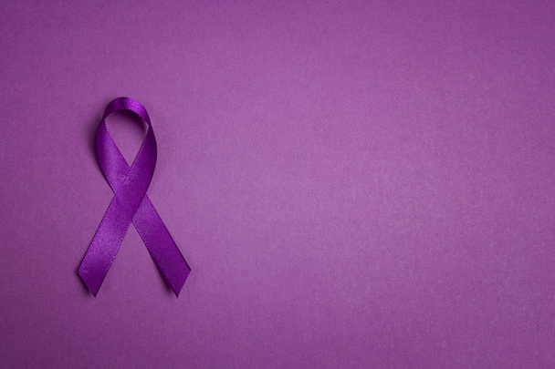 Purple epilepsy awareness ribbon on a purple background with cop - 写真・画像
