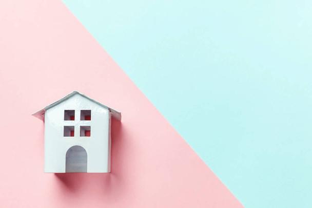 Miniatűr fehér játék ház, kék és rózsaszín pasztell háttér - Fotó, kép