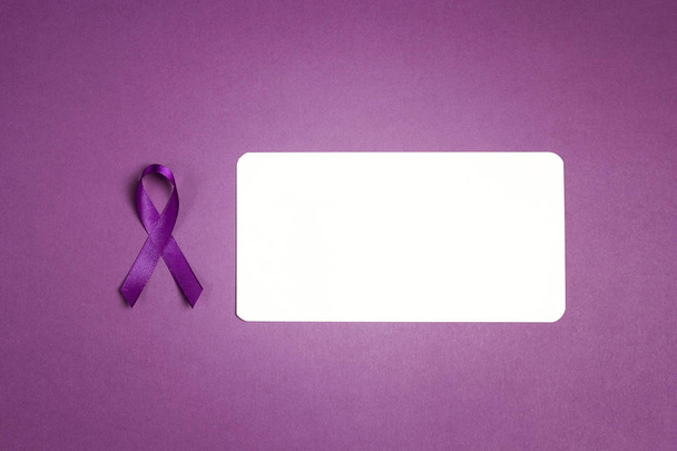 Purple epilepsy awareness ribbon with empty white card on a purp - 写真・画像