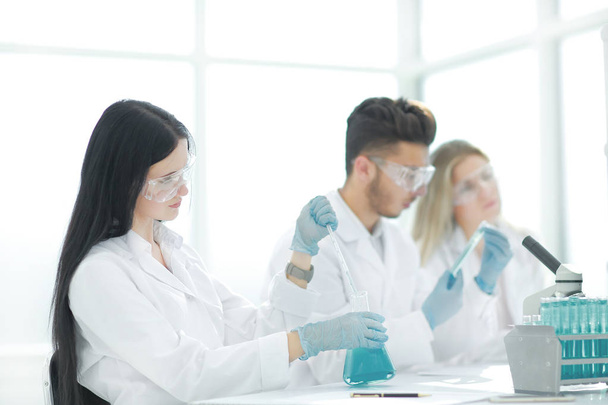 close up.modern woman sitting with colleagues at the laboratory table. - Photo, Image