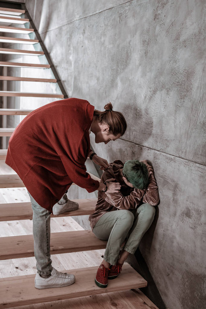 Boyfriend calming his emotional girlfriend sitting on stairs and crying - Фото, зображення