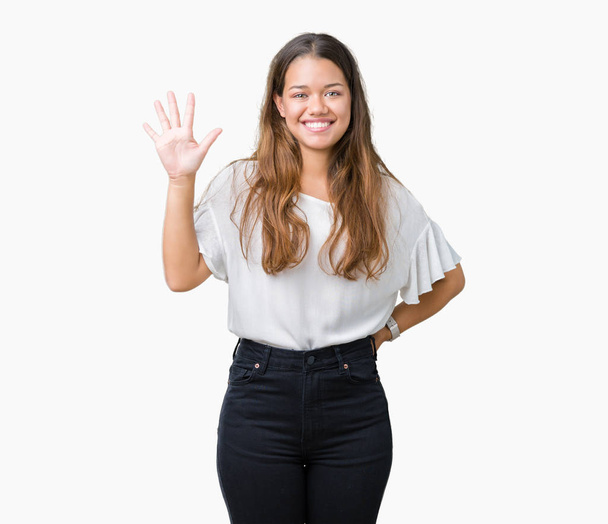 Young beautiful brunette business woman over isolated background showing and pointing up with fingers number five while smiling confident and happy. - Fotó, kép