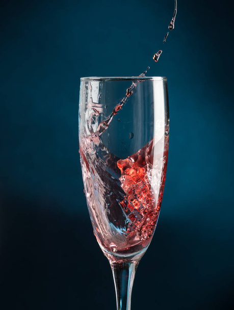 splash in a champagne glass from falling red wine on a dark blue background - Foto, Imagem