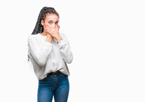Молодий плетені волосся афро-американських дівчата носити взимку светр над ізольованих фон шоковані прикриття рота руками за помилку. Секретний концепції. - Фото, зображення