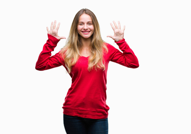Joven hermosa mujer rubia con suéter rojo sobre fondo aislado mostrando y apuntando hacia arriba con los dedos número diez mientras sonríe confiado y feliz
. - Foto, Imagen
