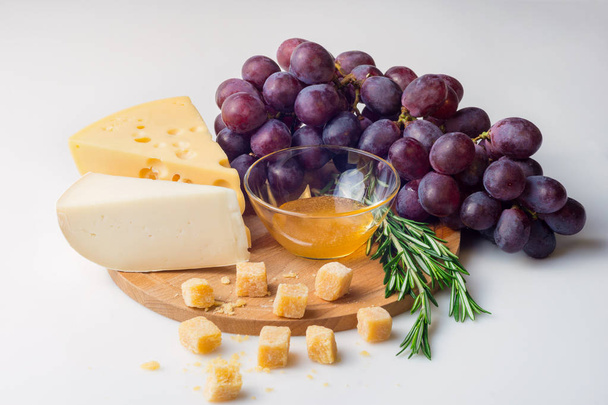 Cheese selection, honey and grape isolated on white background - Foto, Imagem