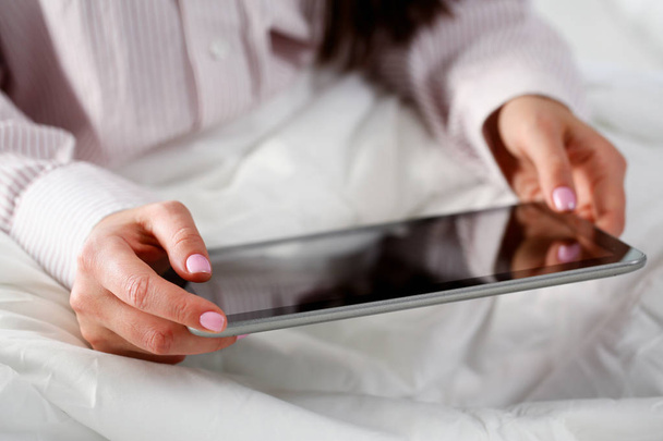 vrouwelijke hand houdt tablet in huis het plaatsen terwijl - Foto, afbeelding