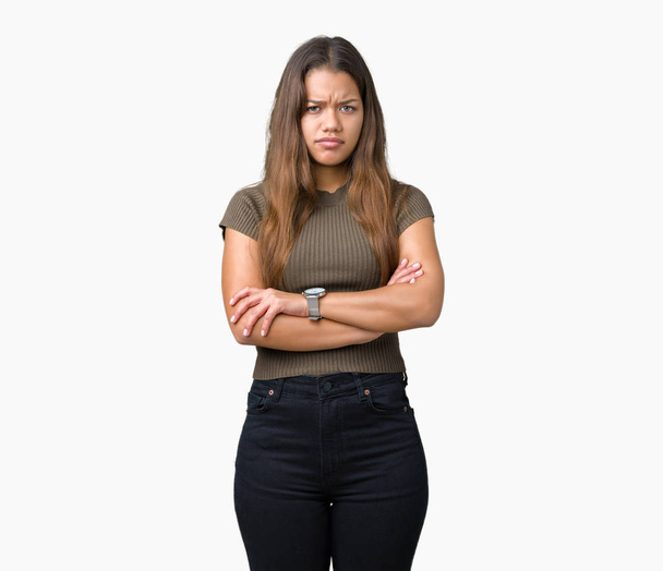 Young beautiful brunette woman over isolated background skeptic and nervous, disapproving expression on face with crossed arms. Negative person. - Photo, Image