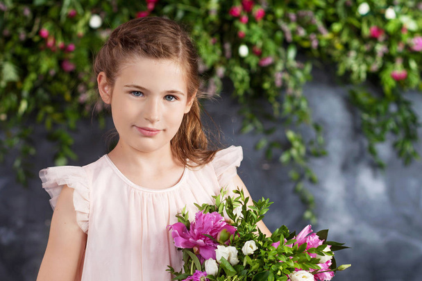 Portrait of the lovely little girl with a bouquet of flowers. Lo - Foto, immagini