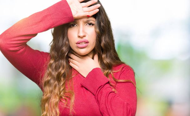 Young beautiful woman wearing red sweater Touching forehead for illness and fever, flu and cold, virus sick - Photo, Image