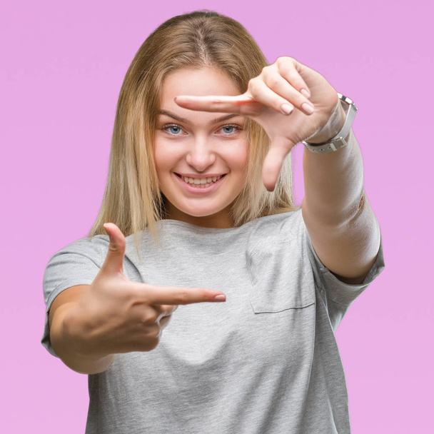 Young caucasian woman over isolated background smiling making frame with hands and fingers with happy face. Creativity and photography concept. - Photo, Image