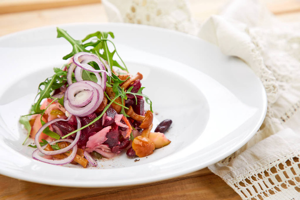 salade végétarienne à la betterave et miel agarique à l'oignon rouge sur assiette blanche, gros plan
  - Photo, image
