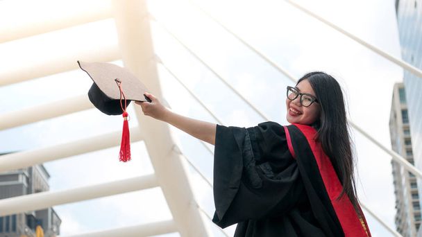 Mädchen in schwarzen Kleidern und Diplom-Diplom lächelnd mit glücklichen Abschluss. - Foto, Bild