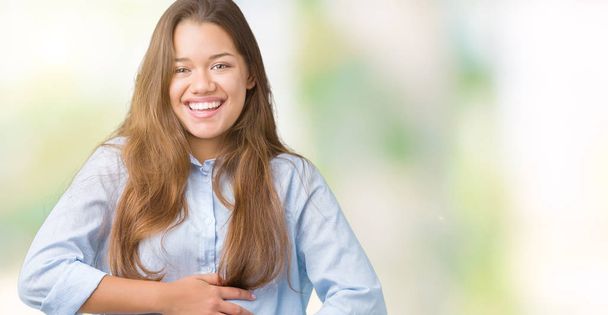 Young beautiful brunette business woman over isolated background Smiling and laughing hard out loud because funny crazy joke. Happy expression. - Photo, Image