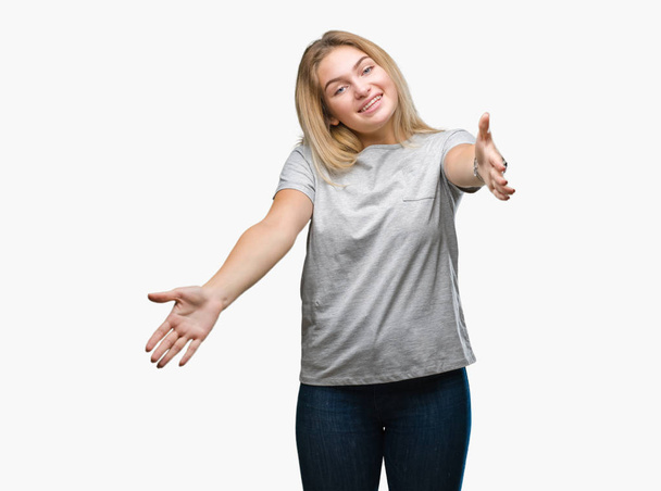 Young caucasian woman over isolated background looking at the camera smiling with open arms for hug. Cheerful expression embracing happiness. - Photo, Image