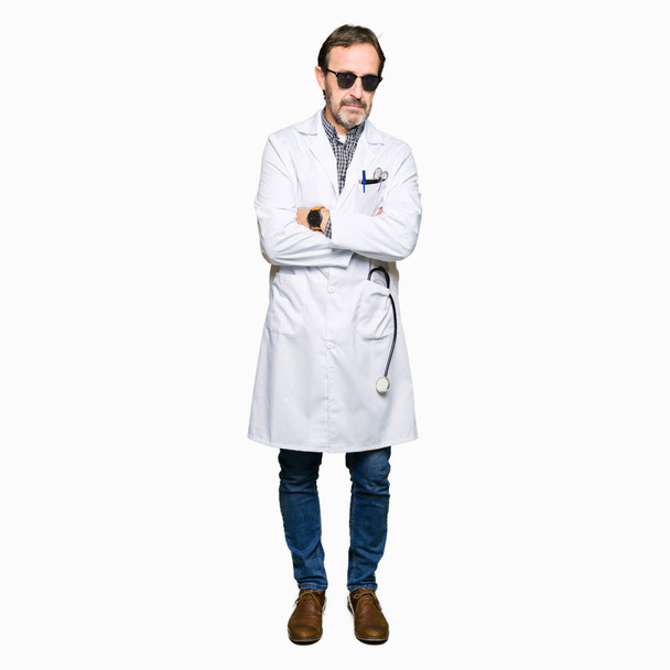 Handsome middle age doctor man wearing sunglasses skeptic and nervous, disapproving expression on face with crossed arms. Negative person. - Photo, Image