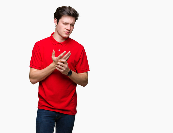 Young handsome man wearing red t-shirt over isolated background Suffering pain on hands and fingers, arthritis inflammation - Foto, immagini