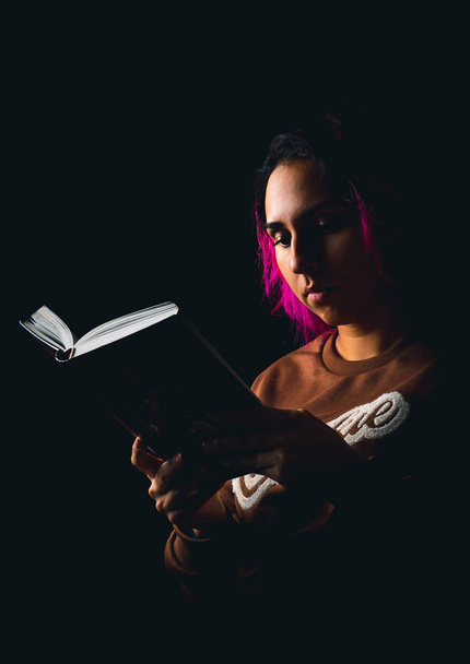 Genç kadın siyah arka plan düşük k ile ilgili bir kitap okuma portresi - Fotoğraf, Görsel