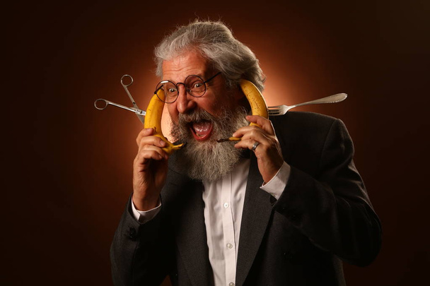 Gözlük ve çatalım giyen bir gri saçlı yaşlı beyefendi, shaggy bıyık ve sakal, bir beyaz gömlek ve gri ceket ile portresi - Fotoğraf, Görsel