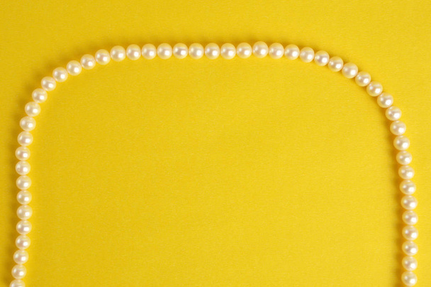 Pearl necklace on yellow - Photo, Image