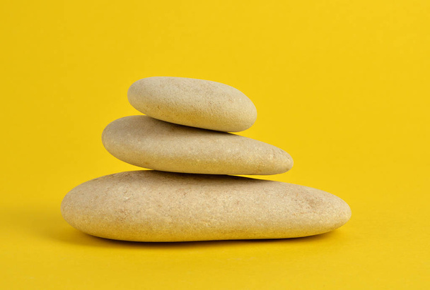 Piedras de spa sobre fondo amarillo
 - Foto, Imagen