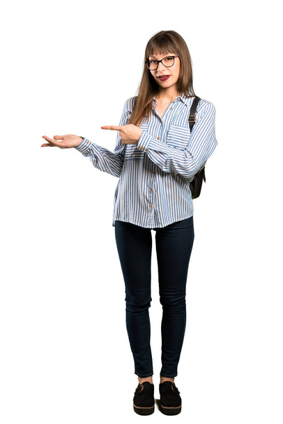 Full-length shot of Woman with glasses holding copyspace imaginary on the palm to insert an ad - Photo, Image