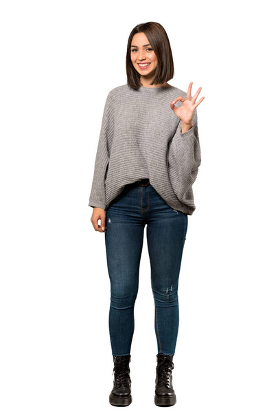 A full-length shot of a Young woman showing ok sign with fingers over isolated white background - Photo, Image