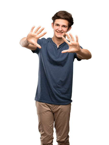 Teenager man counting ten with fingers over isolated white background - Фото, зображення