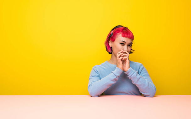 Young woman with pink hair scheming something - Photo, Image
