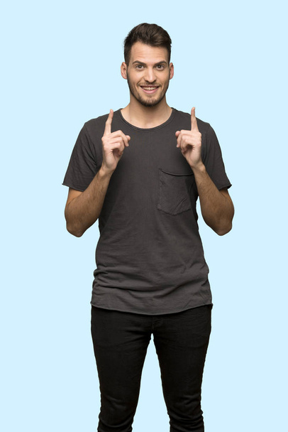 Man with black shirt pointing with the index finger a great idea over blue background - Φωτογραφία, εικόνα