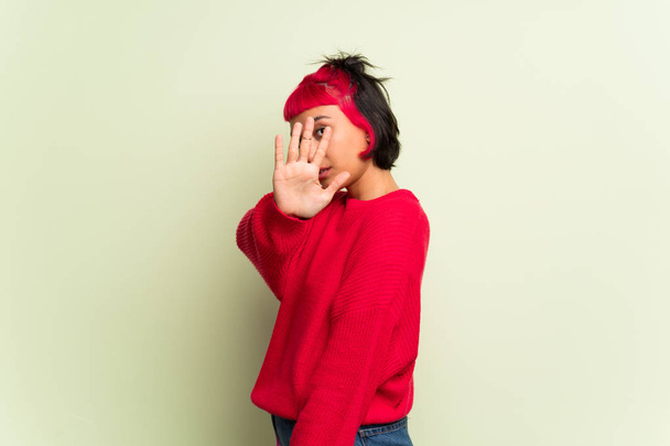 Νεαρή γυναίκα με το κόκκινο πουλόβερ κάνοντας στάση χειρονομία για απογοητευμένος με άποψη - Φωτογραφία, εικόνα