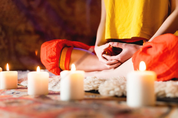 Close-up of womans hand in yoga lotus pose meditating in a crafting room with candles - Fotografie, Obrázek