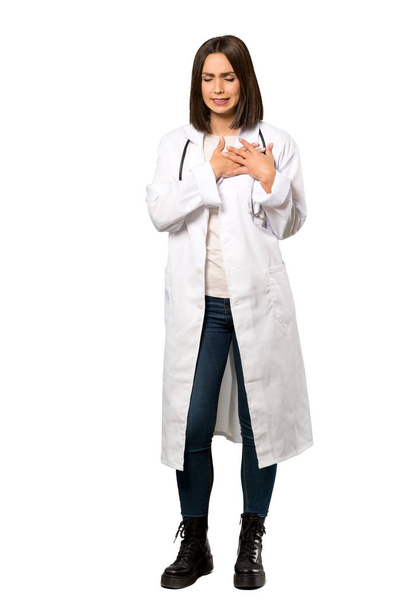 Een full-length shot van een jonge vrouw die een pijn in het hart over geïsoleerde witte achtergrond doctor - Foto, afbeelding