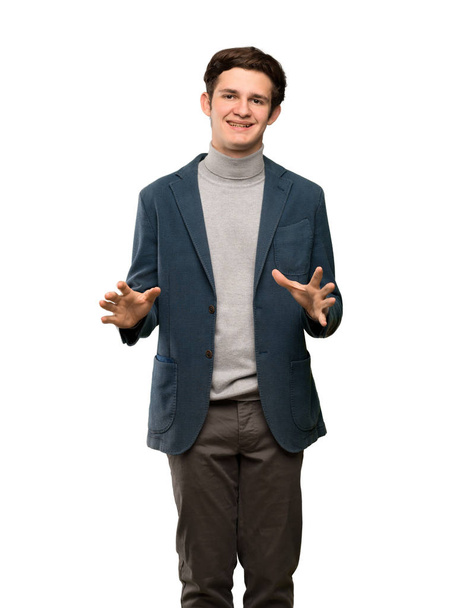 Έφηβο άντρα με ζιβάγκο χαμογελά πάνω από απομονωμένες λευκό φόντο - Φωτογραφία, εικόνα
