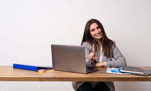 Business woman in a office showing and lifting a finger - Photo, Image