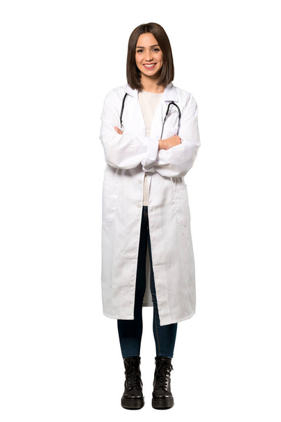 A full-length shot of a Young doctor woman keeping the arms crossed in frontal position over isolated white background - 写真・画像